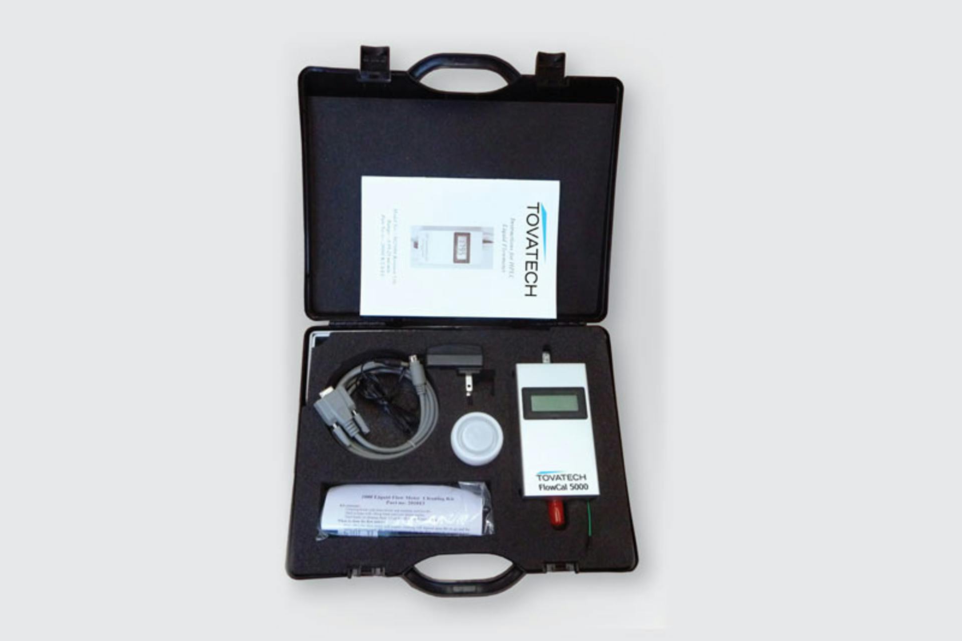 A digital liquid flowmeter in its travel case. Image courtesy of Tovatech LLC.