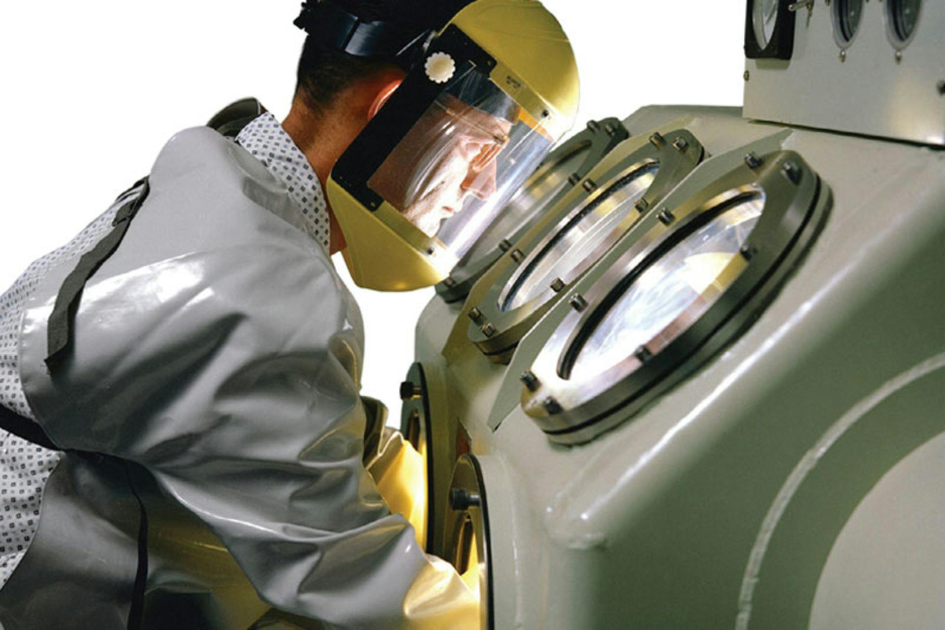 A 1962 photo shows the use of a glovebox for handling sensitive materials. Image courtesy of NASA