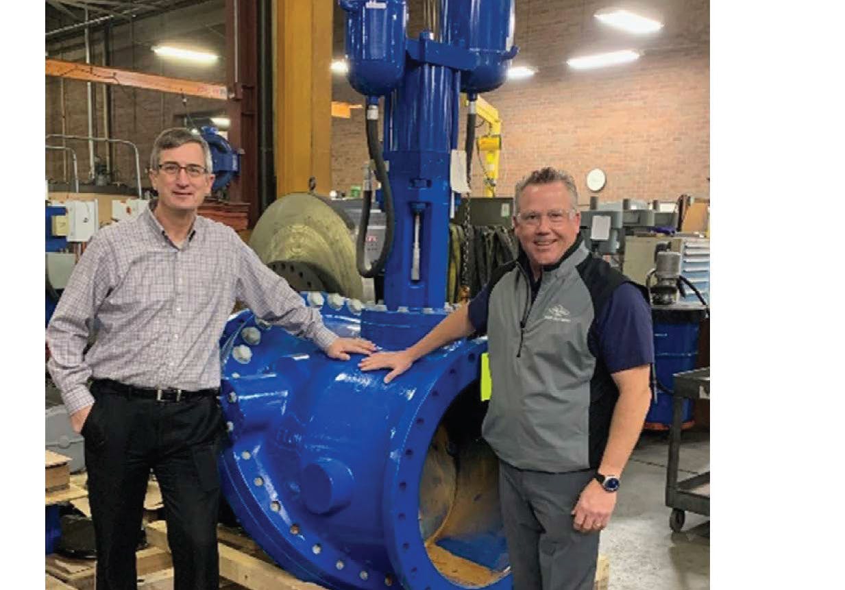 John Ballun and Rob McDonald standing next to a 30' Tilted Disc Check Valve at Val-Matic&rsquo;s Elmhurst facility.