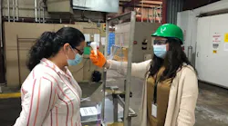 Utilizing infrared non-contact temperature devices, trained testers check the temperatures of associates entering a Perdue Farms facility in Schulenberg, Texas.