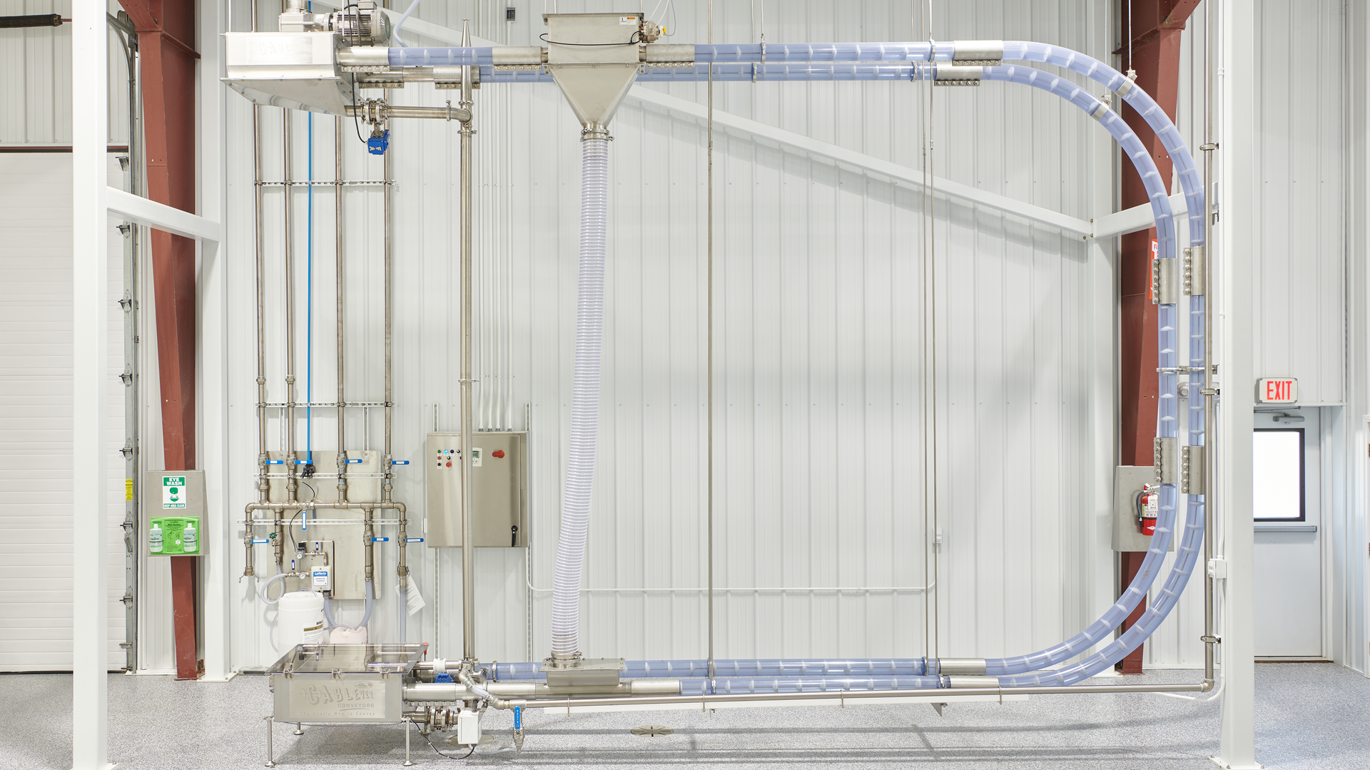 Tubular cable conveyors move product through a sealed tube using a coated, flexible stainless-steel drag cable pulled through on a loop. Solid circular discs are attached to the cable, which push the product at low speed through the tube without the use of air, preserving product integrity and minimizing waste.