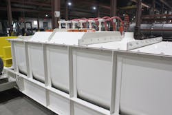 Pugmill mixer with raised cover assembly and spray system. A venting port can also be seen. Pugmill mixer with raised cover assembly and spray system. A venting port can also be seen.