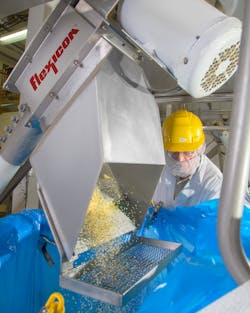 Caster-mounted hoppers and flexible screw conveyors transport work-in-process and bulk shipment material into each bulk bag. Caster-mounted hoppers and flexible screw conveyors transport work-in-process and bulk shipment material into each bulk bag.