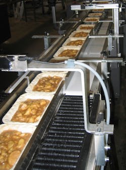Ready-to-eat meals being conveyed after tray filling. Ready-to-eat meals being conveyed after tray filling.