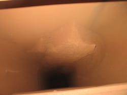 Figure 2: An example of sticky ore buildup in a feed chute to a rotary dryer. Figure 2: An example of sticky ore buildup in a feed chute to a rotary dryer.