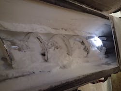 Figure 4: Wet cake feeding to a vacuum dryer with heavy buildup throughout the feeder’s auger and trough. Figure 4: Wet cake feeding to a vacuum dryer with heavy buildup throughout the feeder’s auger and trough.