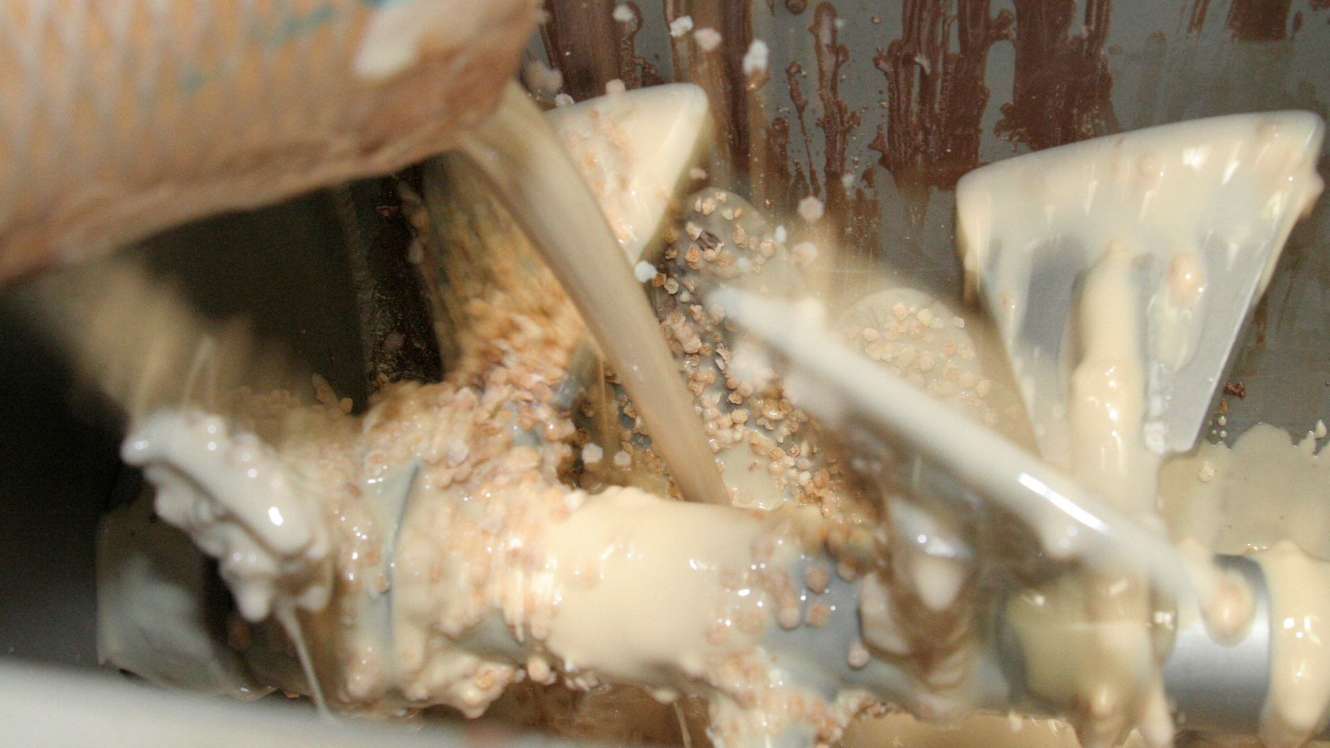 Milk, melted chocolate, chopped almonds and other ingredients are mixed in this Gericke continuous mixer. Each ingredient needs to be fed into the mixer at the predetermined temperature, moisture content and bulk density to ensure a consistently homogeneous mix.