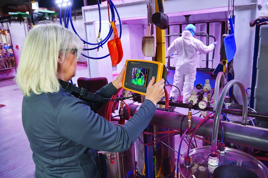 A worker using a Fluke ii900 Sonic Industrial Imager.