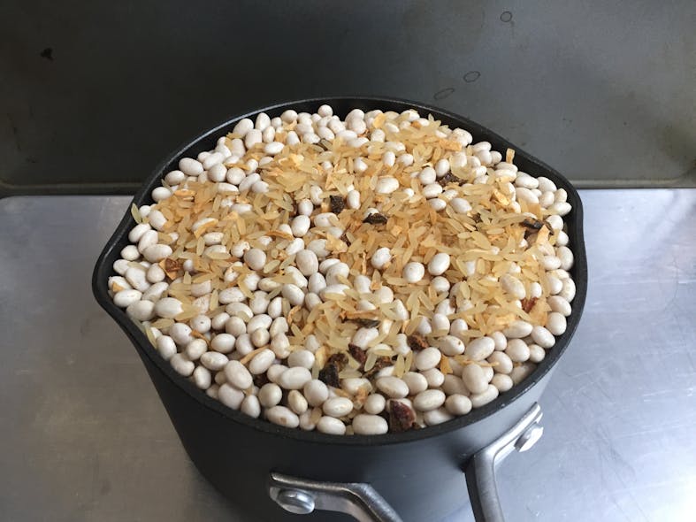 To minimize segregation in free-flowing mixtures such as the rice and beans shown here, transfer the mixture into the measuring container using a spoon and thoroughly stir the sample before taking each spoonful.