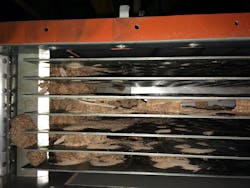 Caked material flaking off upstream surfaces and entering the vertical plate moving bed heat exchanger in this NPK fertilizer application previously led to plugging before the addition of a screen in the inlet hopper above the bank of plates. Caked material flaking off upstream surfaces and entering the vertical plate moving bed heat exchanger in this NPK fertilizer application previously led to plugging before the addition of a screen in the inlet hopper above the bank of plates.