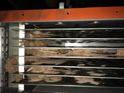 Caked material flaking off upstream surfaces and entering the vertical plate moving bed heat exchanger in this NPK fertilizer application previously led to plugging before the addition of a screen in the inlet hopper above the bank of plates. Caked material flaking off upstream surfaces and entering the vertical plate moving bed heat exchanger in this NPK fertilizer application previously led to plugging before the addition of a screen in the inlet hopper above the bank of plates.