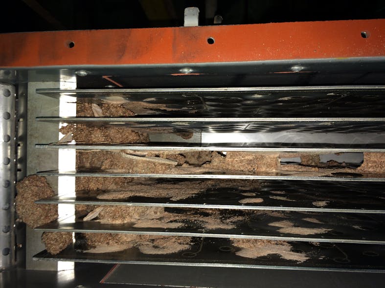 Caked material flaking off upstream surfaces and entering the vertical plate moving bed heat exchanger in this NPK fertilizer application previously led to plugging before the addition of a screen in the inlet hopper above the bank of plates.