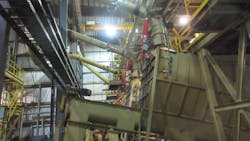 A hammermill with attached plenum is shown with remote dust aspiration and attached chemical suppression bottles that rapidly release chemical suppressant to extinguish fire in its early stages inside the mill when triggered. A hammermill with attached plenum is shown with remote dust aspiration and attached chemical suppression bottles that rapidly release chemical suppressant to extinguish fire in its early stages inside the mill when triggered.