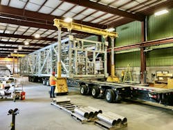 A horizontal-built truckable module being loaded indoors for transportation to the final project. A horizontal-built truckable module being loaded indoors for transportation to the final project.