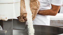 Man pouring powder into a mixer Man pouring powder into a mixer