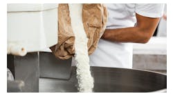 Man pouring powder into a mixer Man pouring powder into a mixer