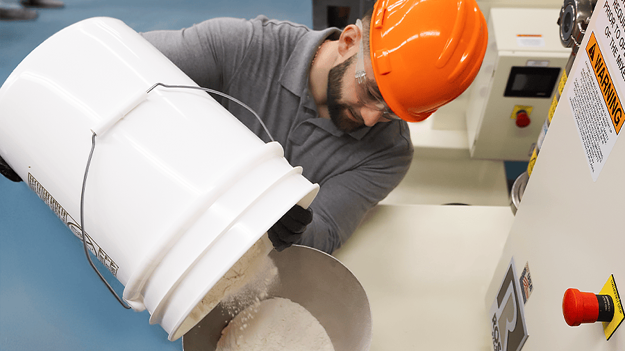 Worker loading flour into a mixer