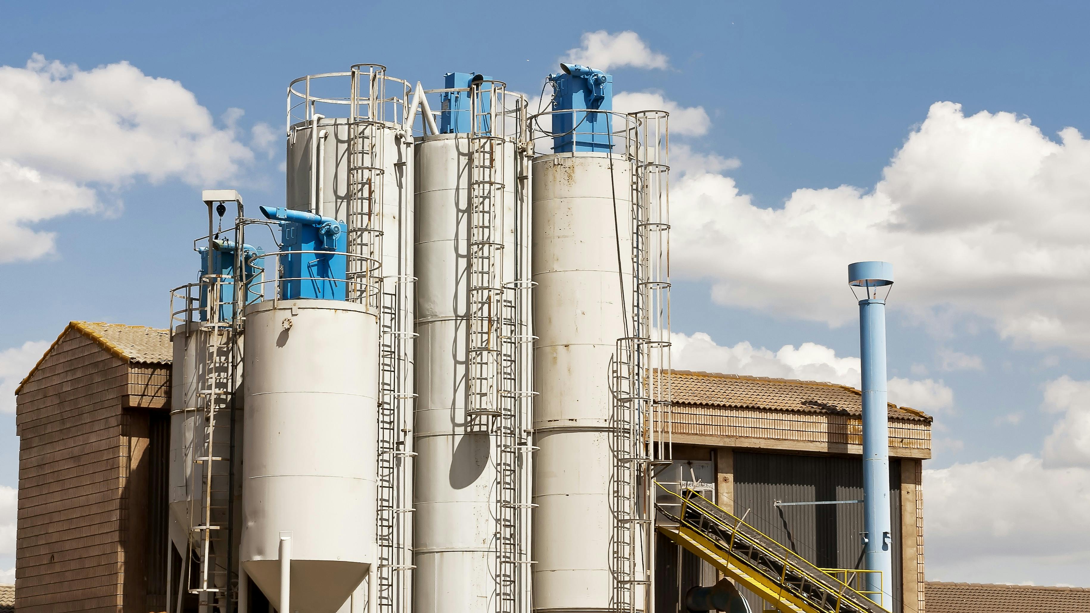 White silos with blue bin vent dust collectors