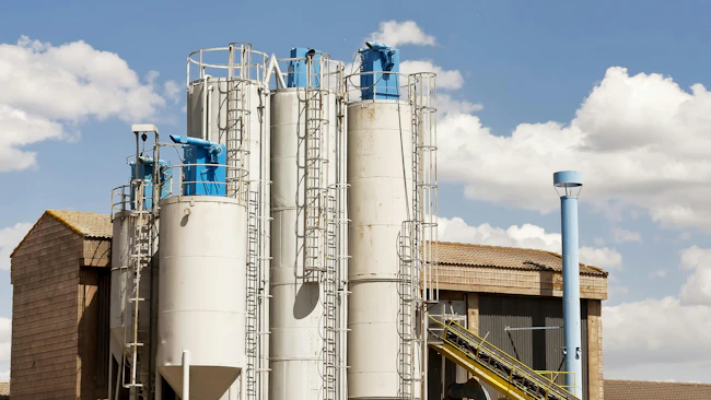 White silos with blue bin vent dust collectors
